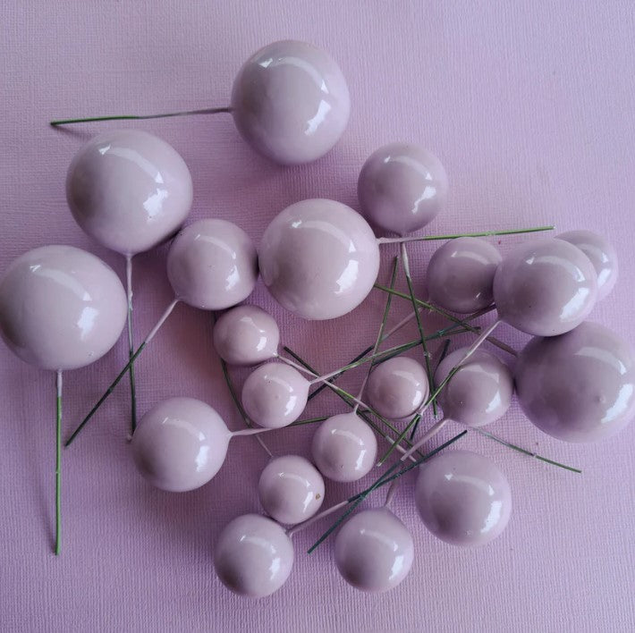 Purple decorative berries on a pink background