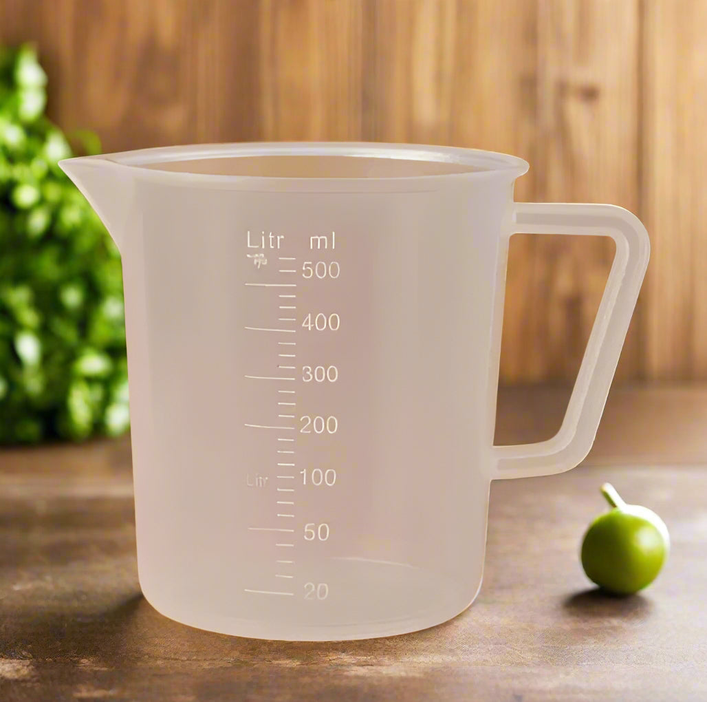 Clear measuring cup with measurement markings on a brown background