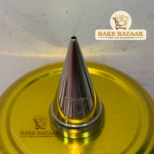 Metallic piping tip on a yellow surface with 'Bake Bazaar' branding.
