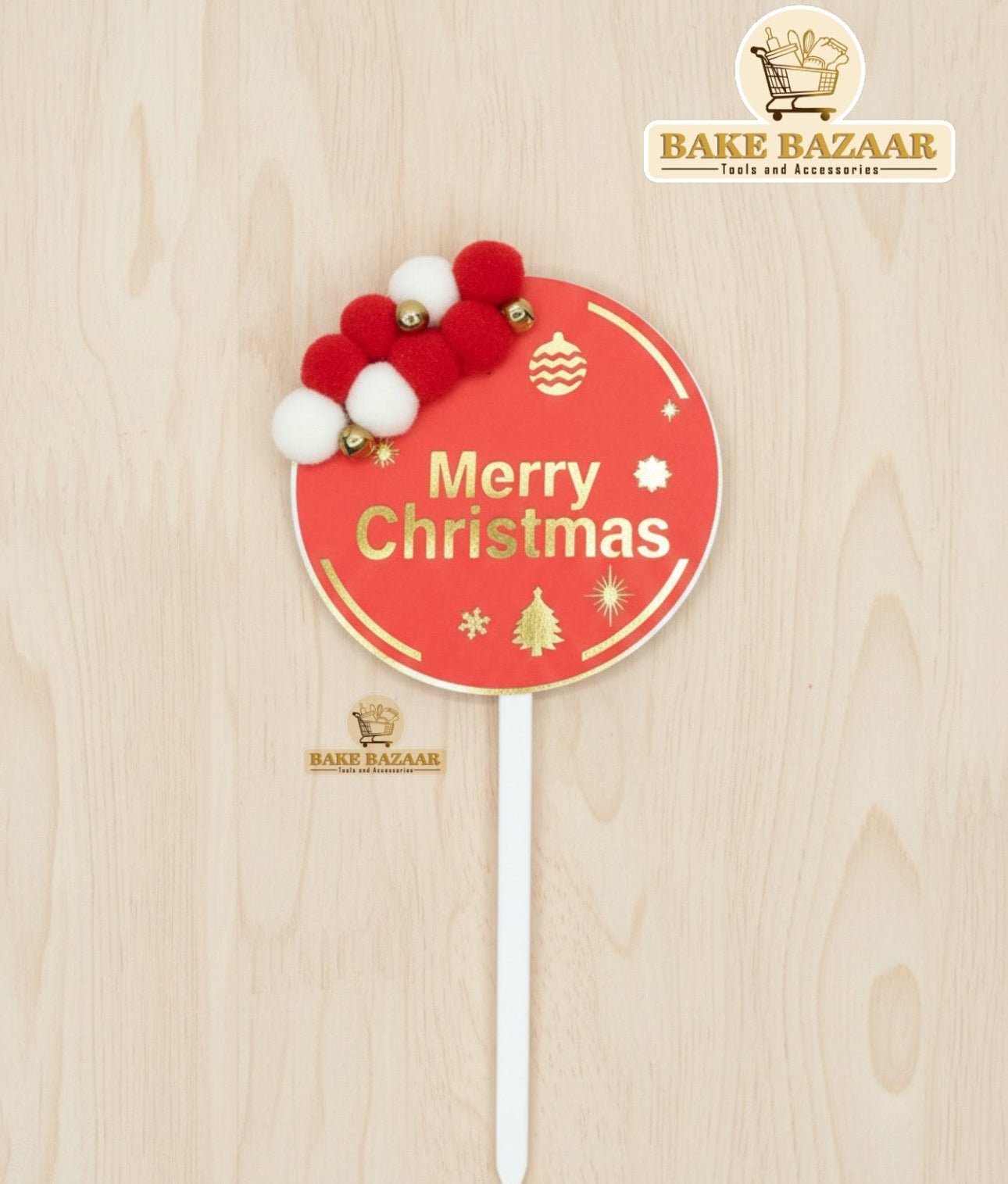 Christmas-themed cake topper with decorative elements on a wooden surface, featuring the Bake Bazaar brand.
