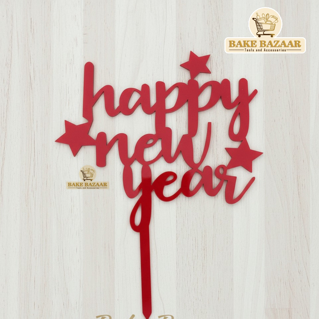 Red 'Happy New Year' cake topper with star decorations on a white background, branded 'Bake Bazaar'.