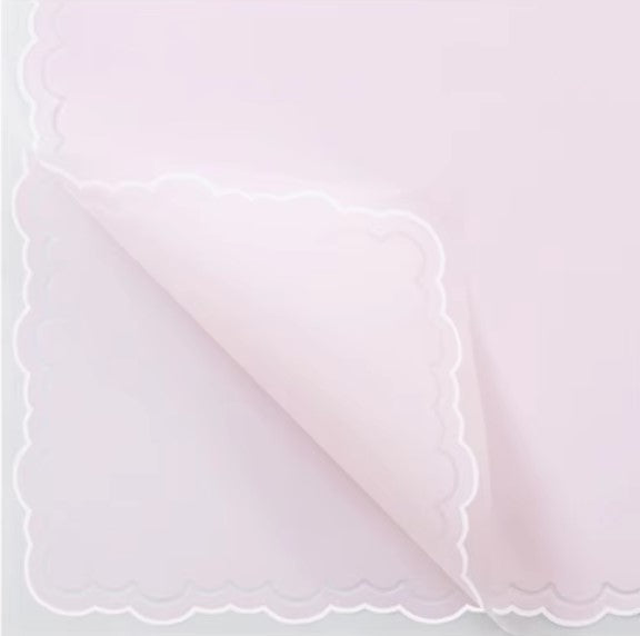 Pink paper with scalloped edge and text on a white background