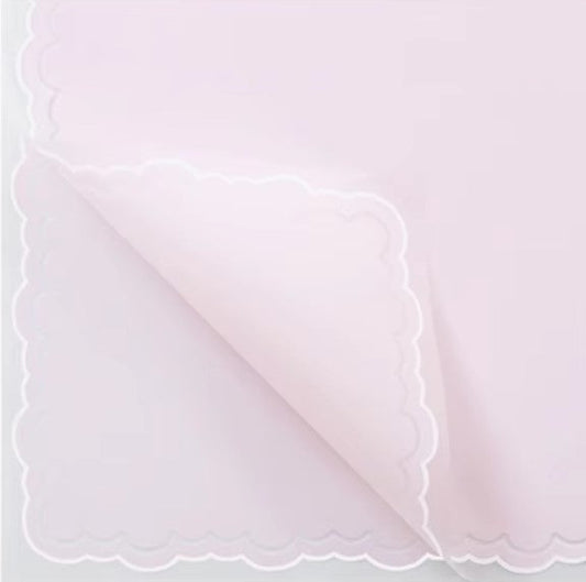 Pink paper with scalloped edge and text on a white background