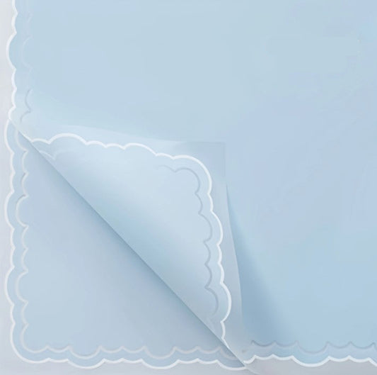 Light blue paper with scalloped edge on a light gray background