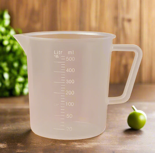 Clear measuring cup with measurement markings on a brown background