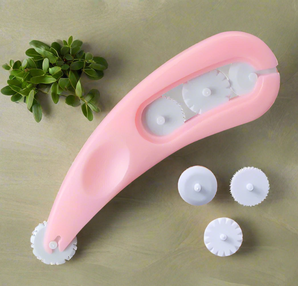 Pink facial roller with multiple attachments on a white background
